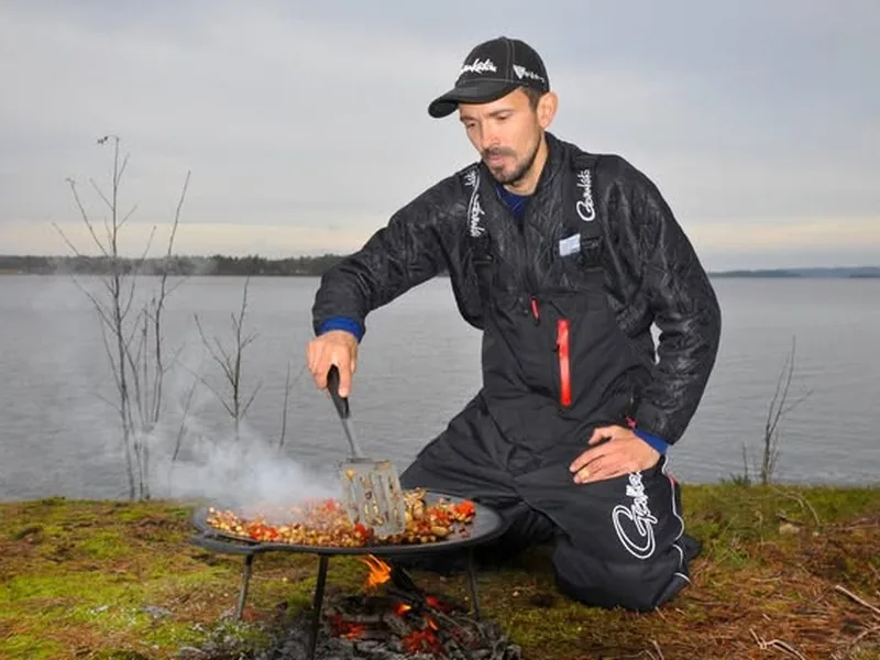 Person i Thermo Underwear vid matlagning utomhus nära vatten